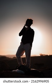 Silhouette Of A Woman Smoking Cigarette On The Hill.