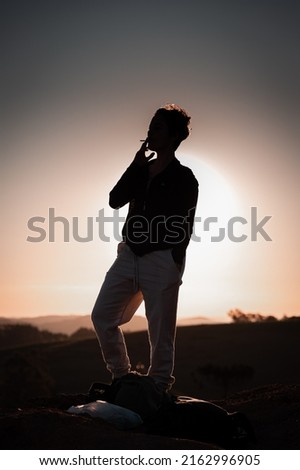 silhouette of a woman smoking cigarette on the hill.