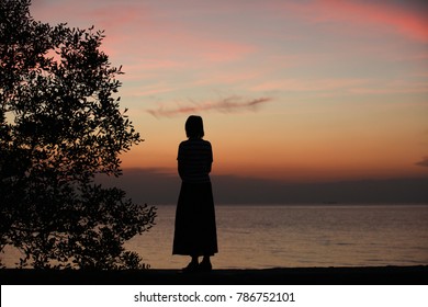 Silhouette Woman Stand Alone At Seaside During Sunset