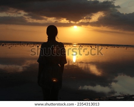 silhouette of a woman at sunset on the beach of gili trawangan island