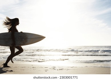 Silhouette, woman surfer run on beach sand and sea, exercise outdoor with surfboard to surf in nature. Sport, shadow and sun with female person running to ocean waves for surfing and mockup space - Powered by Shutterstock