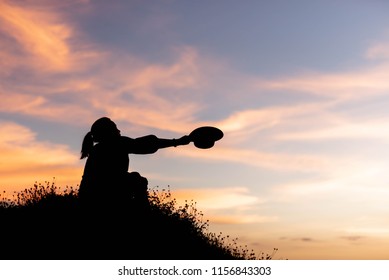 silhouette of woman are using ideas on top of a hill in the sunset - Shutterstock ID 1156843303