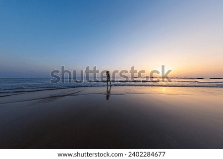 silhouette of a woman walking along the seashore. Spiritual Peace Meditation. A happy girl walks along the seashore against the backdrop of sunset. side view.