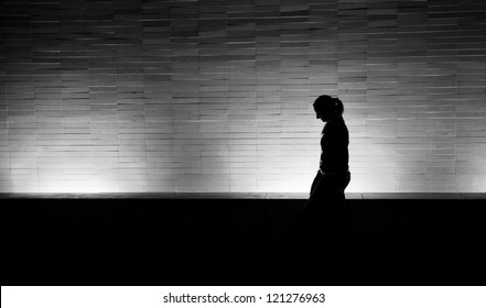 Silhouette Of A Woman Walking At Night In The City