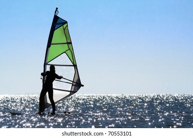 Silhouette Of A Woman Windsurfer On The Sea