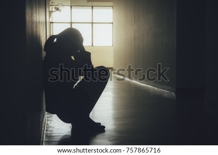 Silhouette of woman/businesswoman sitting head in hands on the modern creative Office. Concept dramatic loneliness, sadness, depression, sad emotions, cry, disappointed.