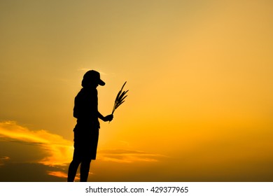 Silhouette women is holding flower with sunrise background. - Shutterstock ID 429377965