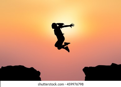 Silhouette women jumping on top mountain