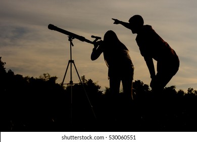 Silhouette women and men see the stars by telescope.
