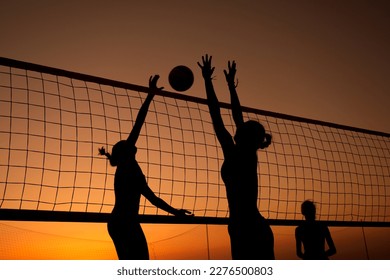 Silhouette women playing beach volleyball on sunset. - Powered by Shutterstock