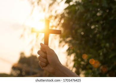 Silhouette wood cross or religion symbol shape over a sunset sky with clouds background for God - Shutterstock ID 1701476425