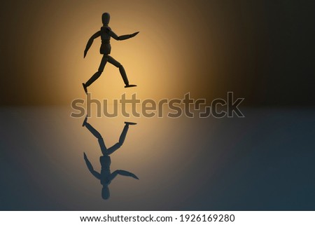 silhouette of wooden dummy running with reflection in the glass. concept of race to success. Space do text