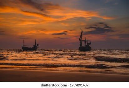 Silhouette wooden fishery boats in the sea with sunset red and warm lighting.