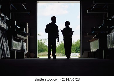 Silhouette Of Workers Communicating At Distribution Warehouse. Copy Space.