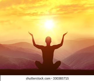  Silhouette of yoga man in the mountains at sunrise