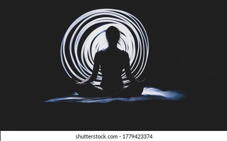 Silhouette Of Yoga Woman At Night With Light Circle In The Background. Light Painting Photography With Long Exposure