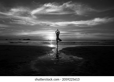 Silhouette Of Yoga Woman On Sea Sunset. Black And White Photo.