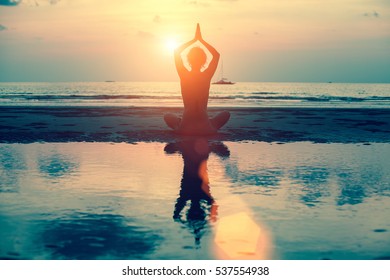 Silhouette yoga woman on the sea beach at sunset. - Shutterstock ID 537554938