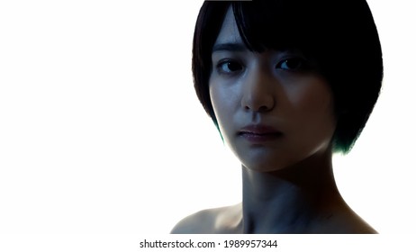 Silhouette of young asian woman turning to camera.