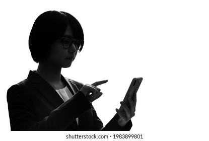 Silhouette Of Young Asian Woman Using A Smart Phone.