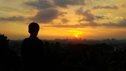 Silhouette Of Young Boy And Kuala Lumpur City During Sunset