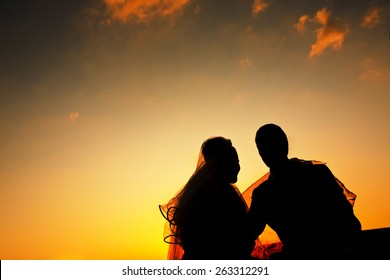 silhouette young bride   groom Sunset background