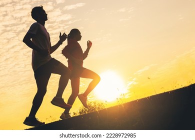 Silhouette of young couple running together on road. Couple, fit runners fitness runners during outdoor workout with sunset background. - Powered by Shutterstock