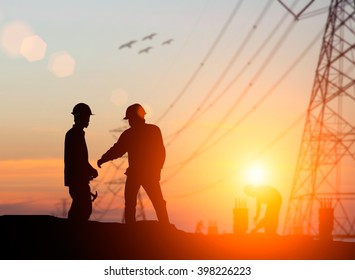 Silhouette The Young Engineer Was Thinking To Comply With Environmental, Construction And The Environment Around Us And Have A Minimal Impact On The Public Over Blurred High Voltage Transmission Lines