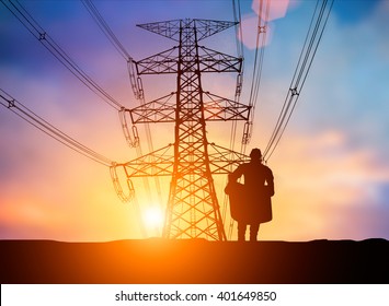 Silhouette The Young Engineer Was Thinking To Comply With Environmental, Construction And The Environment Around Us And Have A Minimal Impact On The Public Over Blurred High Voltage Transmission Lines