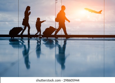 Silhouette of young family and airplane - Shutterstock ID 298605944