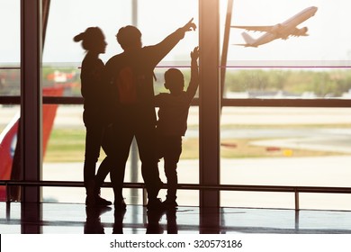 Silhouette Of Young Family At Airport