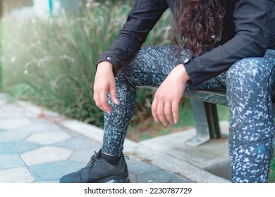Silhouette of young female athlete rests body after exercise. Sporty, strong and healthy woman sitting in the park after exercise. - Shutterstock ID 2230787729