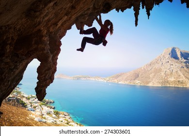 Silhouette of a young female rock climber on a cliff. Kalymnos Island, Greece 