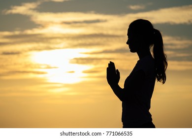 silhouette of a young girl on the beach practicing yoga