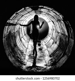 Silhouette Of A Young Girl Walking Through A Storm Sewer Well