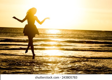 silhouette of young happy woman on water background, outdoor portrait, summer vacations - Powered by Shutterstock