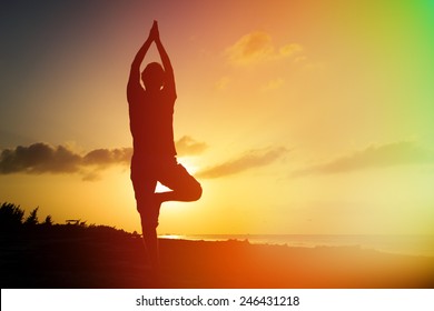 Silhouette Of Young Man Doing Yoga At Sunset Beach