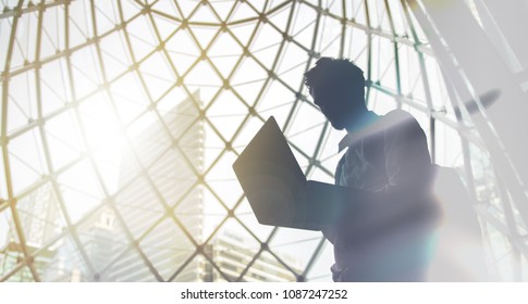 Silhouette of young man with laptop - Shutterstock ID 1087247252