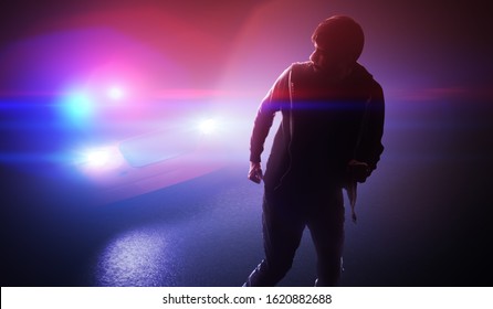 Silhouette of young man - thief escaping from police car at night.