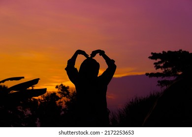 Silhouette Of A Young Muslim Woman Praying In The Afternoon, At Sunset.