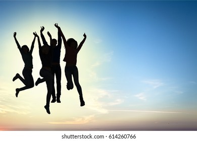 Silhouette of young people jumping. - Shutterstock ID 614260766