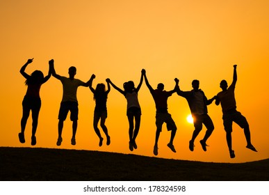 Silhouette of Young People Jumping at Sunset