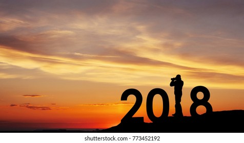 Silhouette young photographer for 2018 new year background of the sunset.