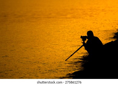 Silhouette of young photographer on the beach.