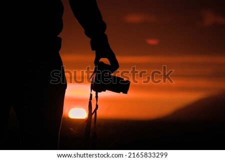 Silhouette of young photographer at sunset sunrise in Iceland