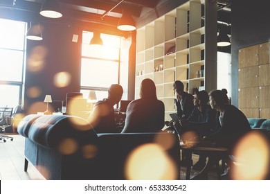 Silhouette Of Young Startup Team. Meeting On The Couch. Big Open Space Office. Five People. Intentional Sun Glare And Lens Flares