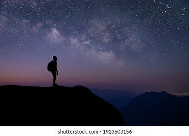 Silhouette of young traveler and backpacker watched the star and milky way alone on top of the mountain.