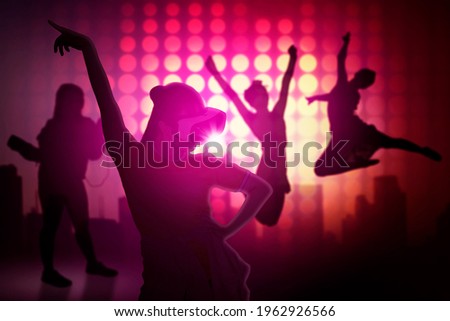 Silhouette of young woman doing dances games in the VR glasses while standing with silhouette of dancer posing background