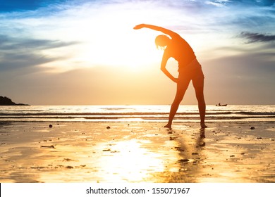 Silhouette Young Woman, Exercise On The Beach At Sunset