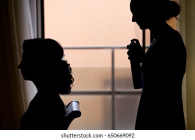 silhouette of young woman getting her hair done before wedding or party. Hairdresser makes hairstyle for the bride. - Shutterstock ID 650669092